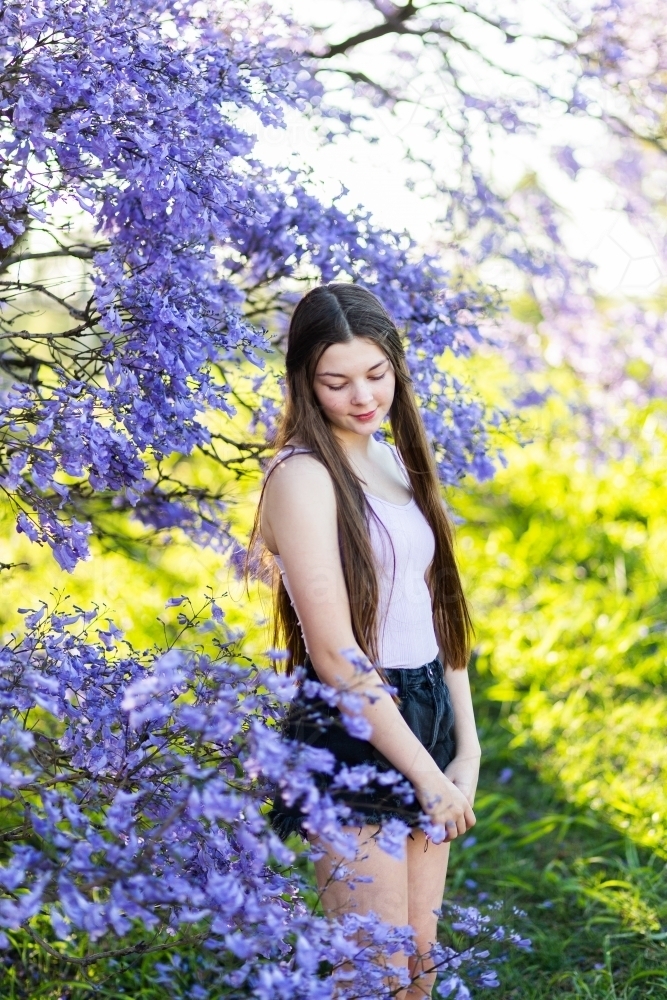 Teen girl with long hair looking down - Australian Stock Image