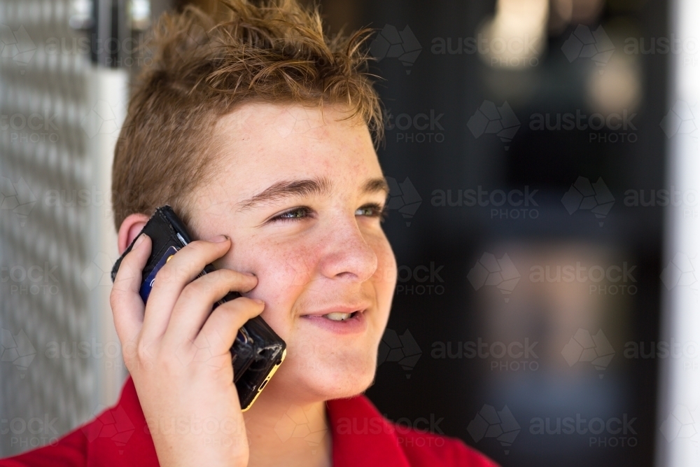 Teenage boy holding phone to his ear - Australian Stock Image