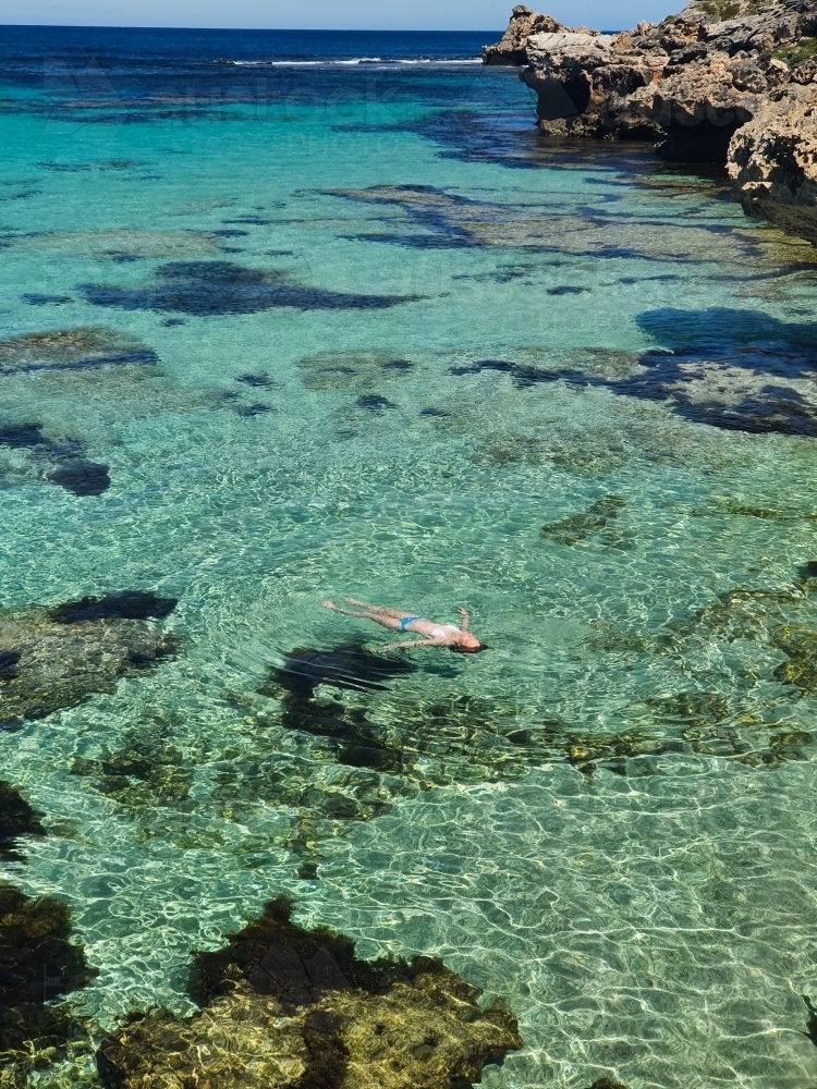 Teenage girl floating in the ocean - Australian Stock Image