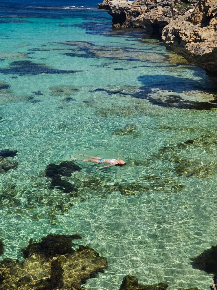 Teenage girl floating in the ocean - Australian Stock Image