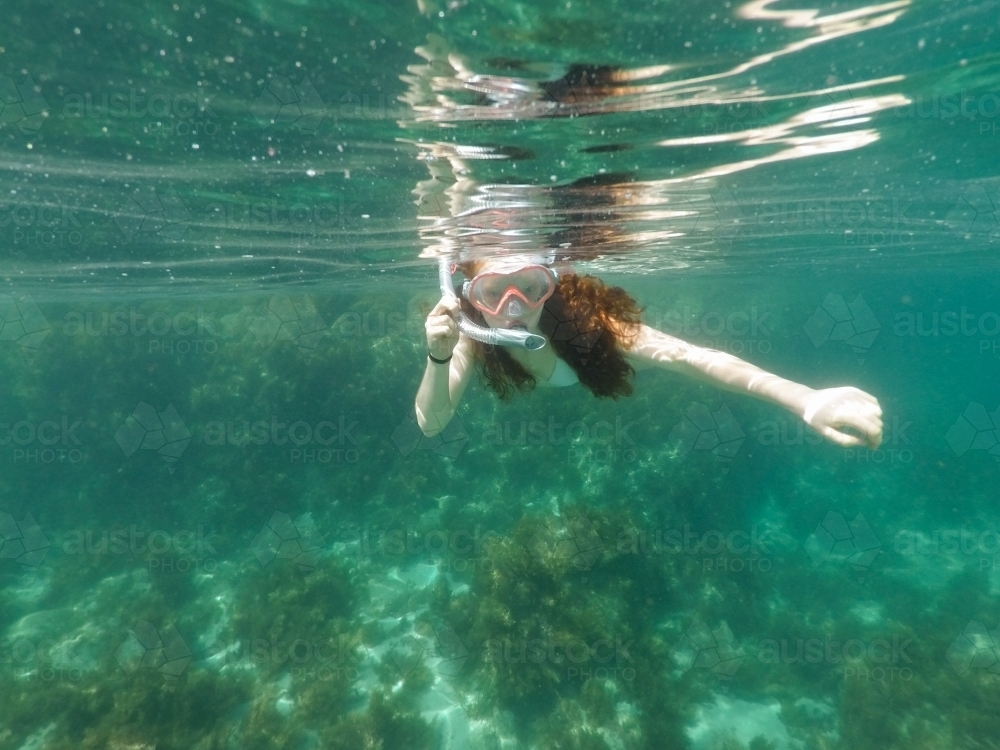 Teenage girl snorkelling in an ocean rockpool - Australian Stock Image