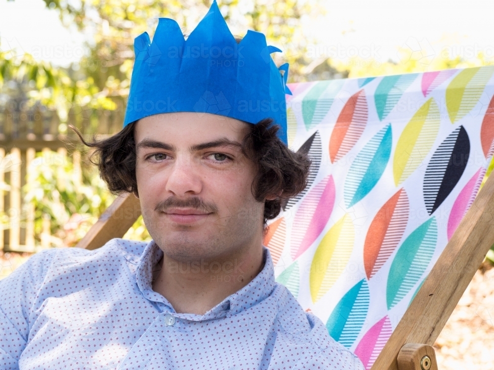 Teenager waers a Christmas cracker hat - Australian Stock Image