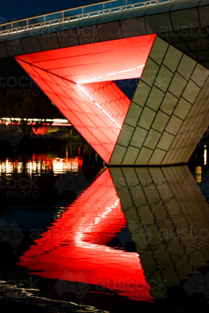The Adelaide Riverbank Precinct Bridge crossing the River Torrens with bright red lights reflected - Australian Stock Image