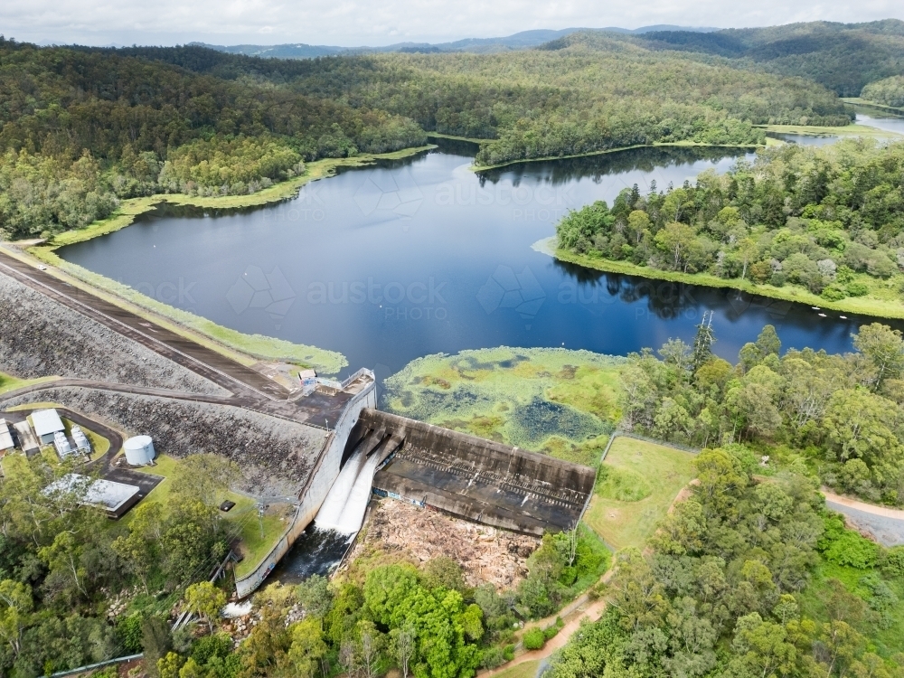 The Enoggera Reservoir, with flowing spillway, in the Brisbane suburb of The Gap - Australian Stock Image