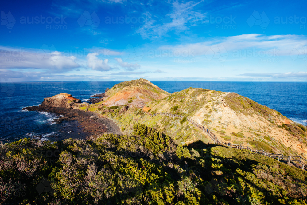 The famous Cape Schanck boardwalk runs towards the sea and rock formation known as London Bridge - Australian Stock Image