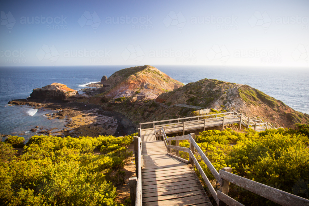 The famous Cape Schanck boardwalk runs towards the sea and rock formation known as London Bridge - Australian Stock Image