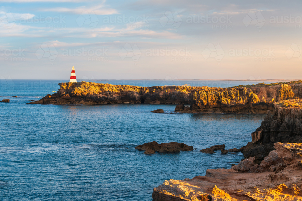 The Robe Obelisk with rugged coastline during sunrise viewed towards the ocean - Australian Stock Image