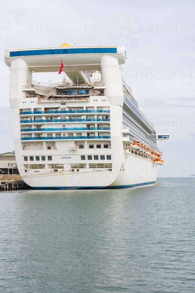 The stern of a large cruise ship docked at shipping terminal - Australian Stock Image