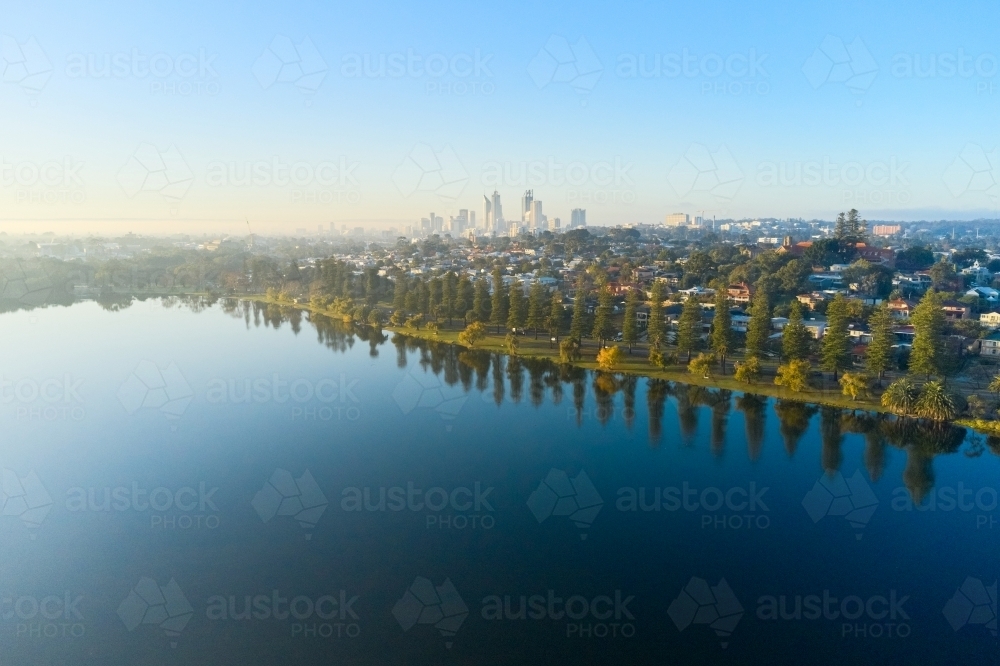 The still waters of Lake Monger on a misty morning, with the Perth City skyline in view - Australian Stock Image