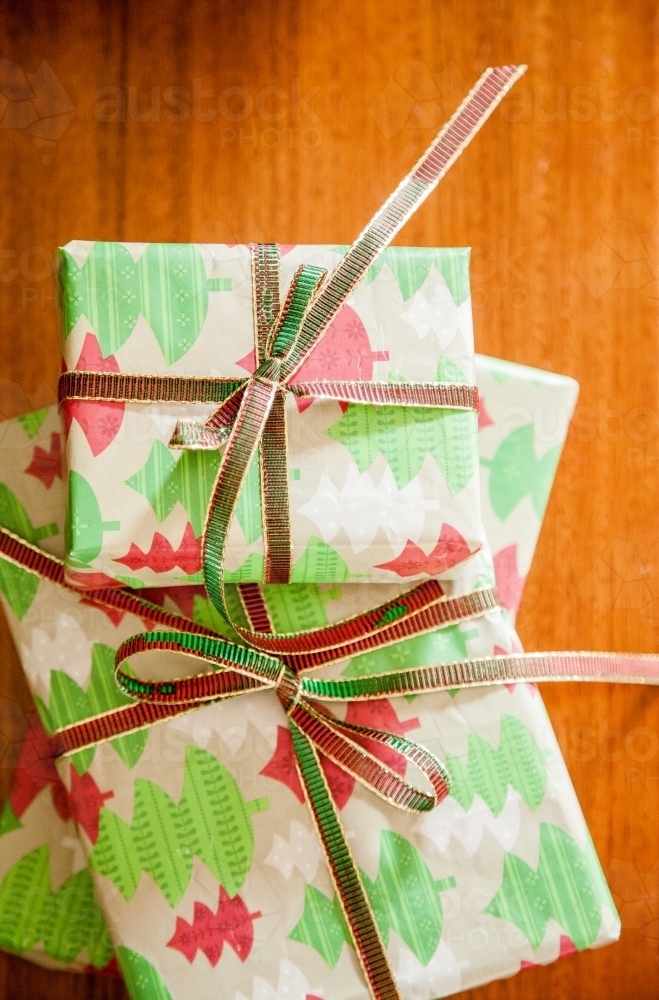 Three brightly wrapped Christmas gifts in a pile - Australian Stock Image