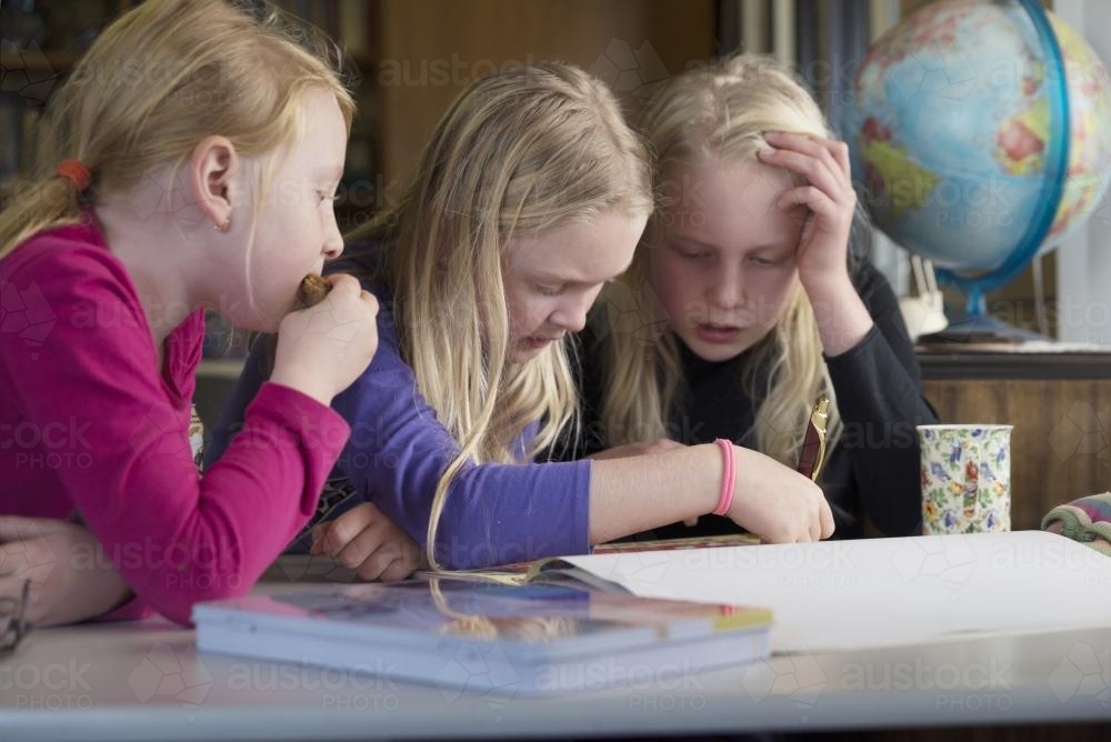 Three girls looking at map - Australian Stock Image