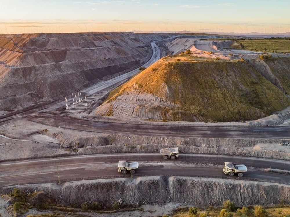 Three mining dump trucks hauling coal in mine site in Hunter Valley - Australian Stock Image