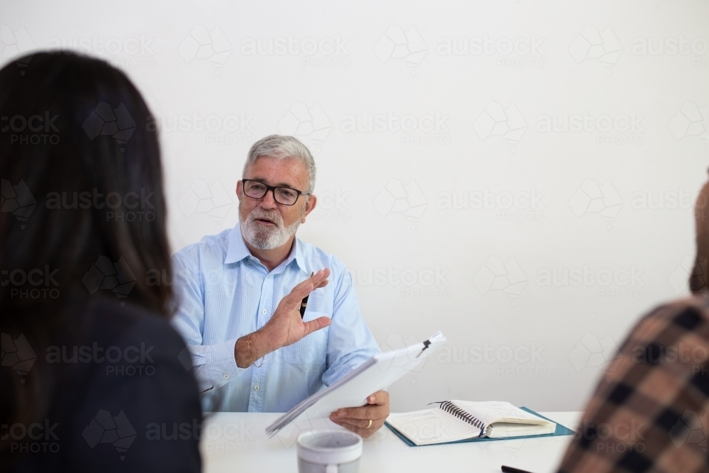 Three people sitting collaborating in an office - Australian Stock Image