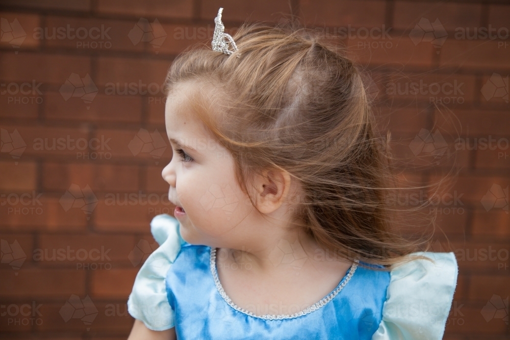 Three year old girl dressed up as a princess outside in the wind - Australian Stock Image