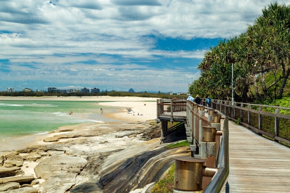 Timber boardwalk and pandanus palm trees by the sea at Caloundra, Queensland. - Australian Stock Image