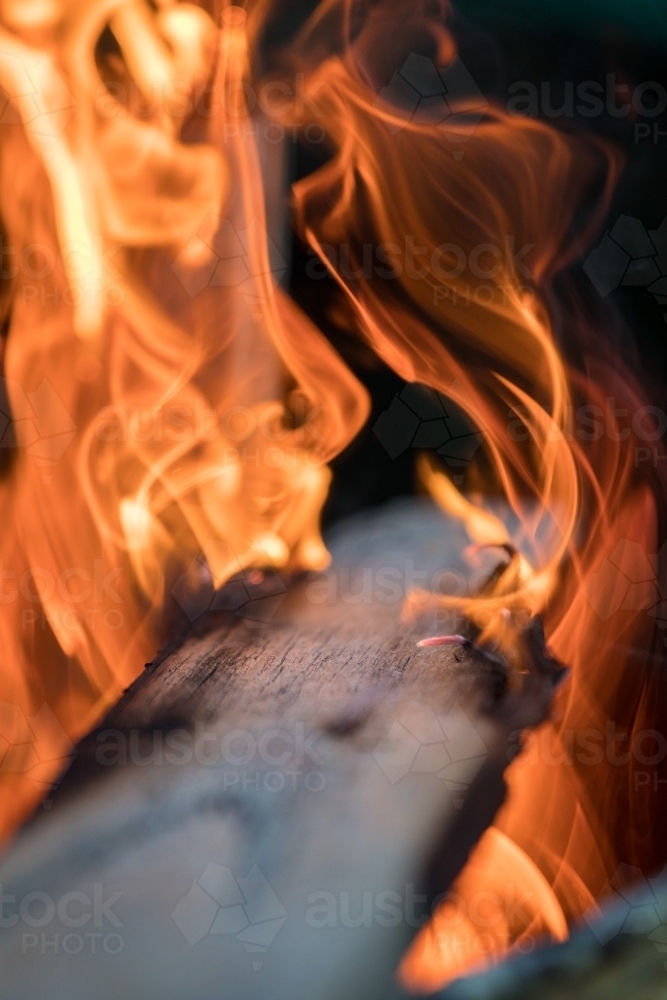 Timber plank on fire with shallow depth of field - Australian Stock Image