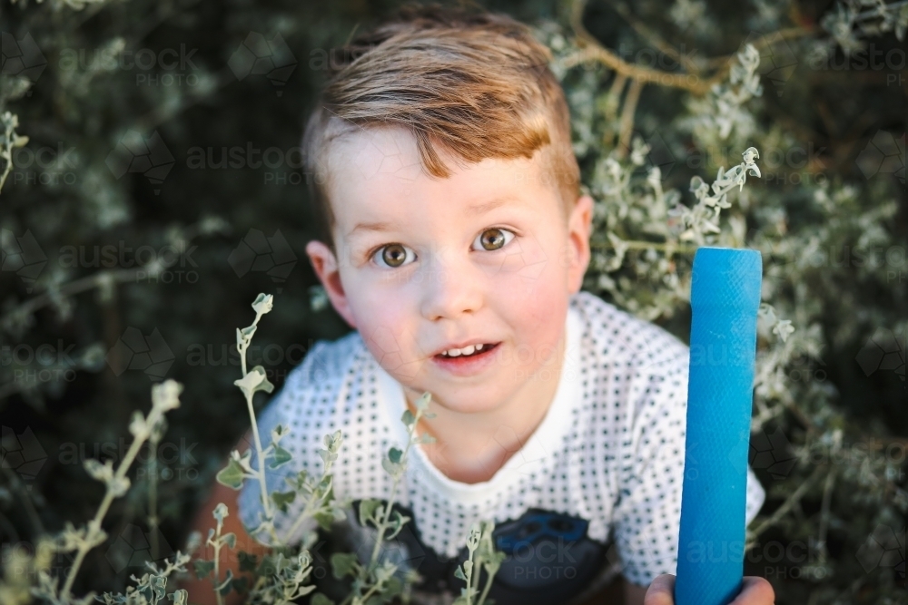 toddler boy with brown hair playing in nature - Australian Stock Image