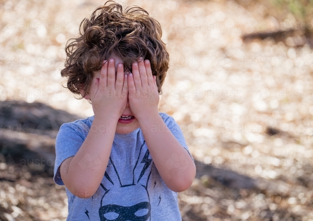 Toddler plays hide and seek game - Australian Stock Image