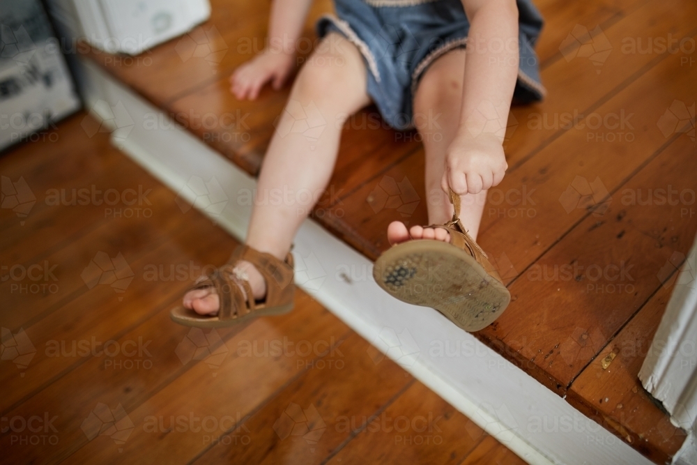 Toddler putting shoes on - Australian Stock Image