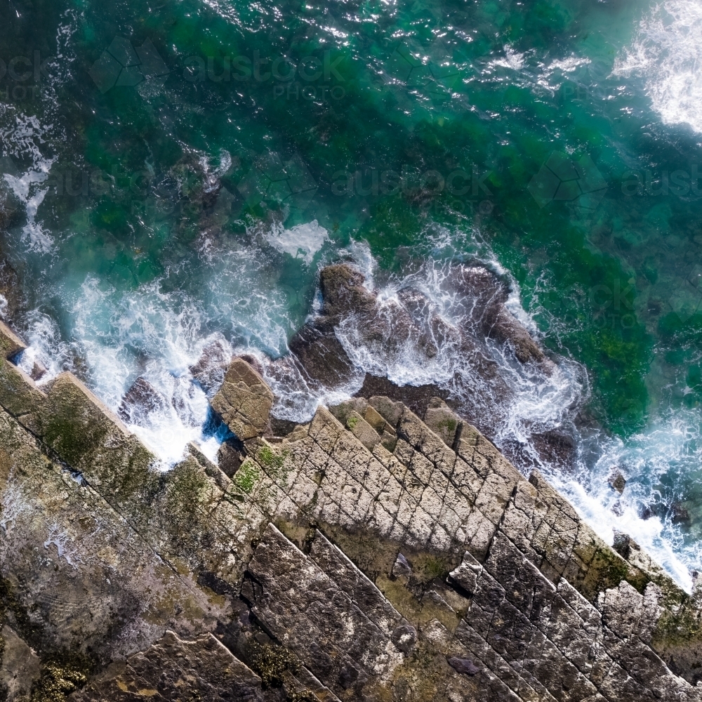 Top down aerial of rock shelf and ocean waves at Turimetta Beach on Sydney's Northern Beaches - Australian Stock Image