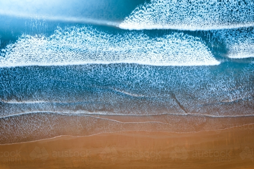 Top Down of sandy shore and waves washing up the beach - Australian Stock Image