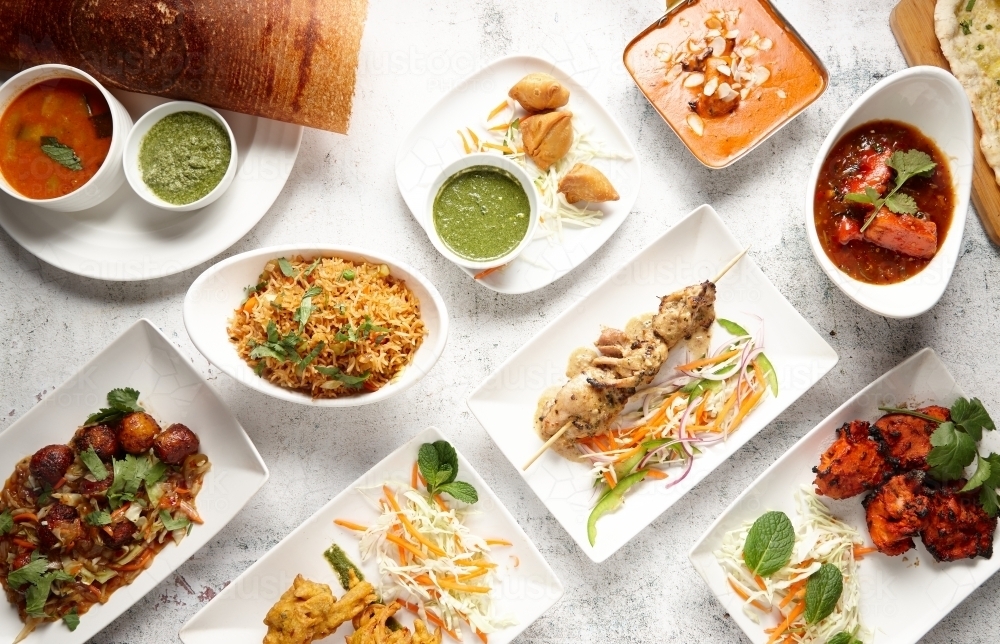 Top down of various appetising Indian dishes on table - Australian Stock Image