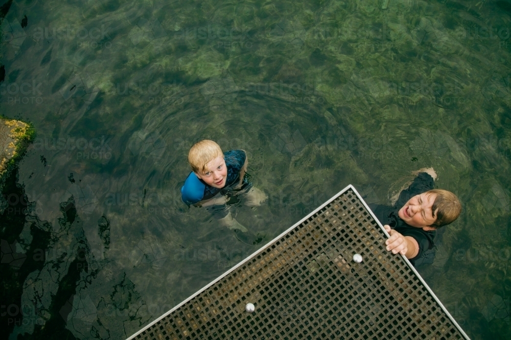 Top view of kids swimming in clear blue water at the Bogey Hole in Newcastle, New South Wales - Australian Stock Image