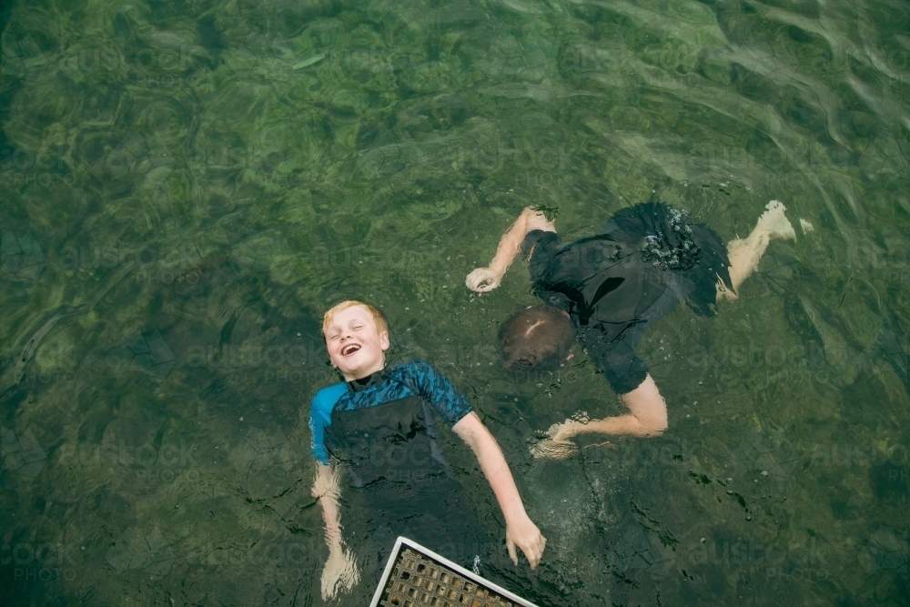 Top view of kids swimming in clear blue water at the Bogey Hole in Newcastle, New South Wales - Australian Stock Image