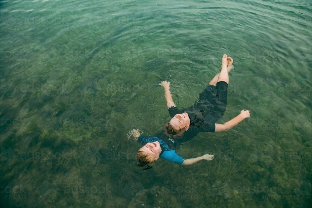 Top view of kids swimming in clear blue water at the Bogey Hole in Newcastle, New South Wales - Australian Stock Image