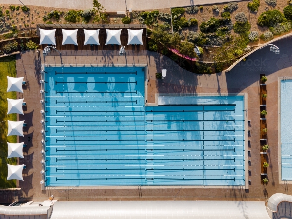 top view shot of a swimming pool with white shade in the sides and trees around it - Australian Stock Image