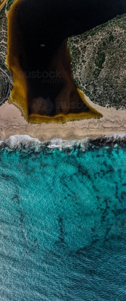 top view shot of a white sand beach with grass, bushes and waves on a sunny day - Australian Stock Image
