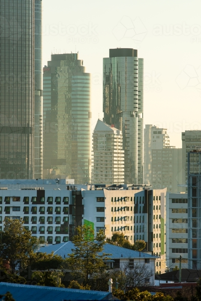 Towers and skyscrapers of Brisbane city on a slight hazy morning, backlit by sunlight. - Australian Stock Image