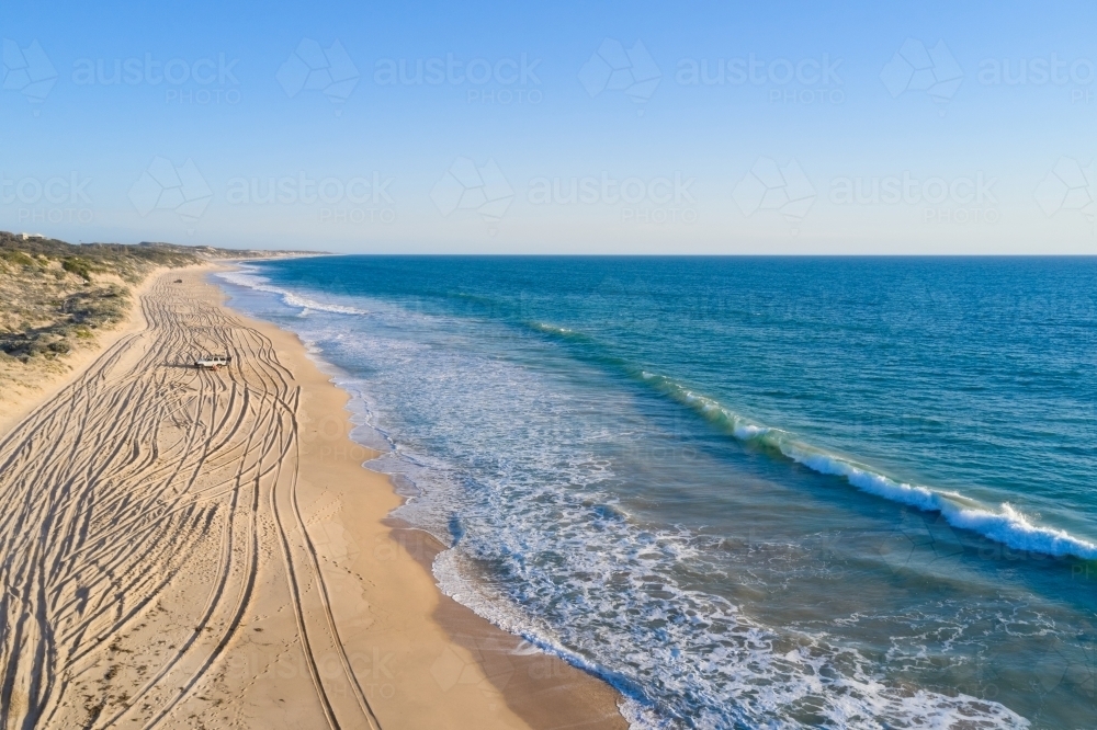 Tracks along a sandy 4x4 beach in Western Australia, with off-road vehicles parked on the beach. - Australian Stock Image