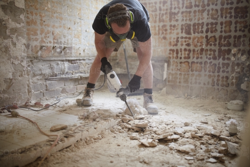 Image of Tradesman jackhammering a floor in a home renovation ...