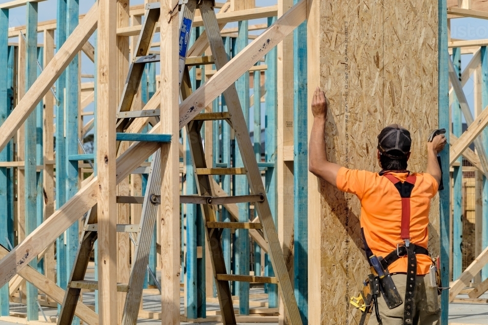 Image of Tradie working on house building site - Austockphoto