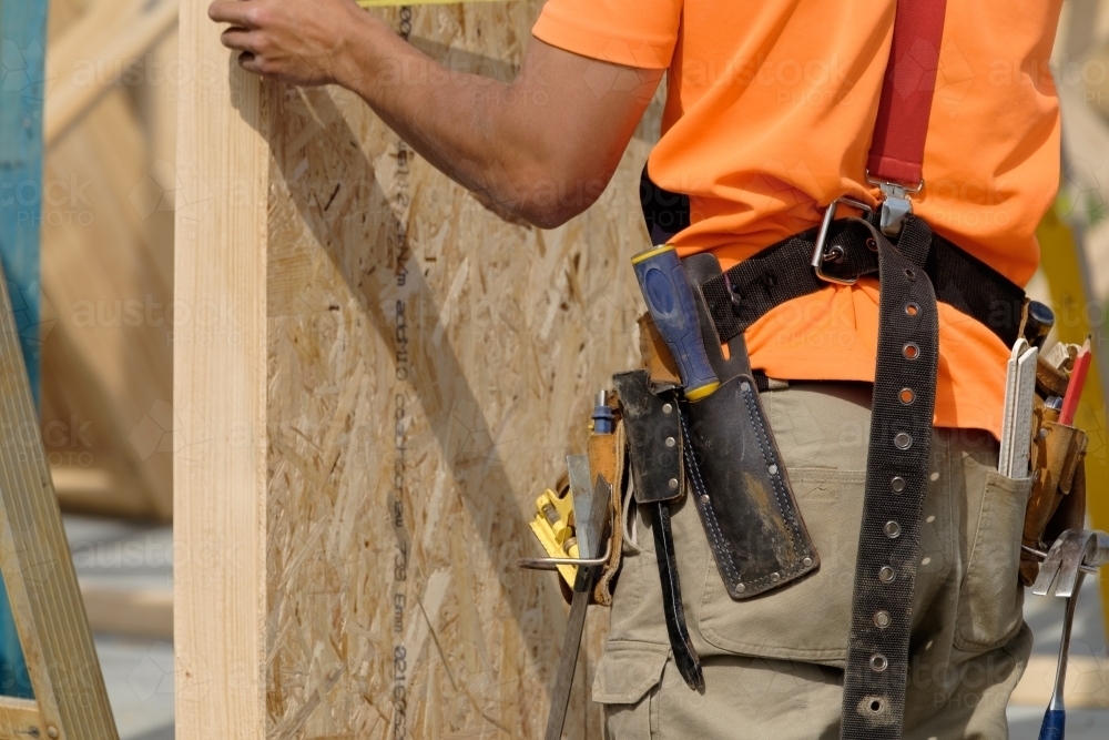 Image of Tradie working on house building site - Austockphoto