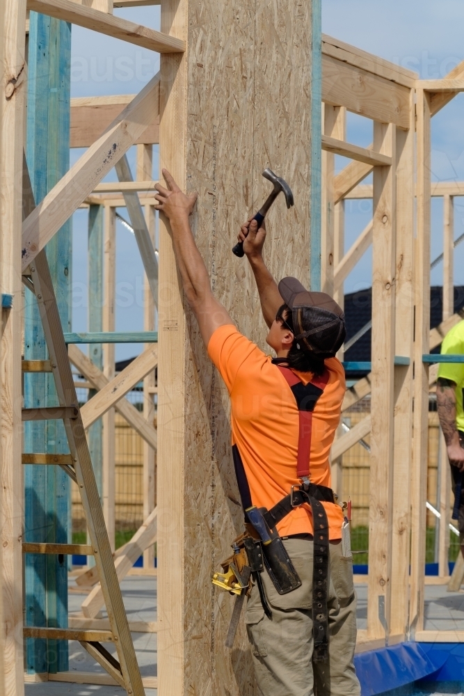 Image of Tradie working on house building site - Austockphoto