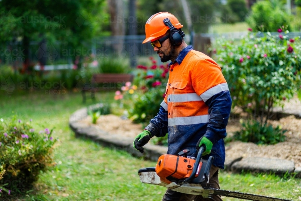 Tradie workman with chainsaw in garden - Australian Stock Image