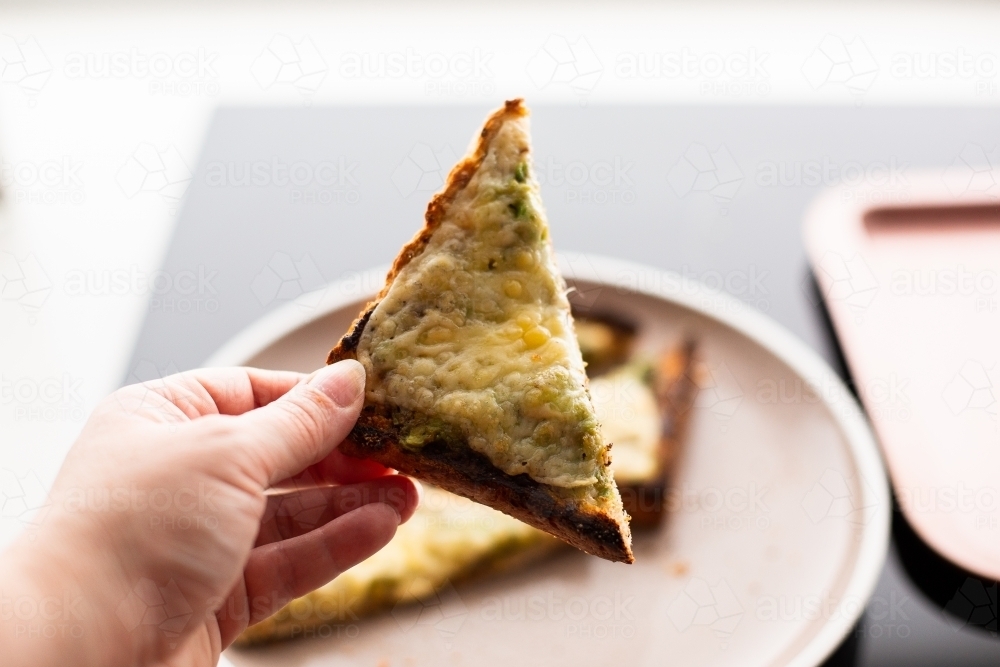 Triangle of cheesy avocado and vegemite toast - Australian Stock Image