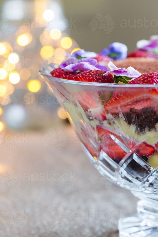 trifle dessert in crystal bowl with fairy lights - Australian Stock Image