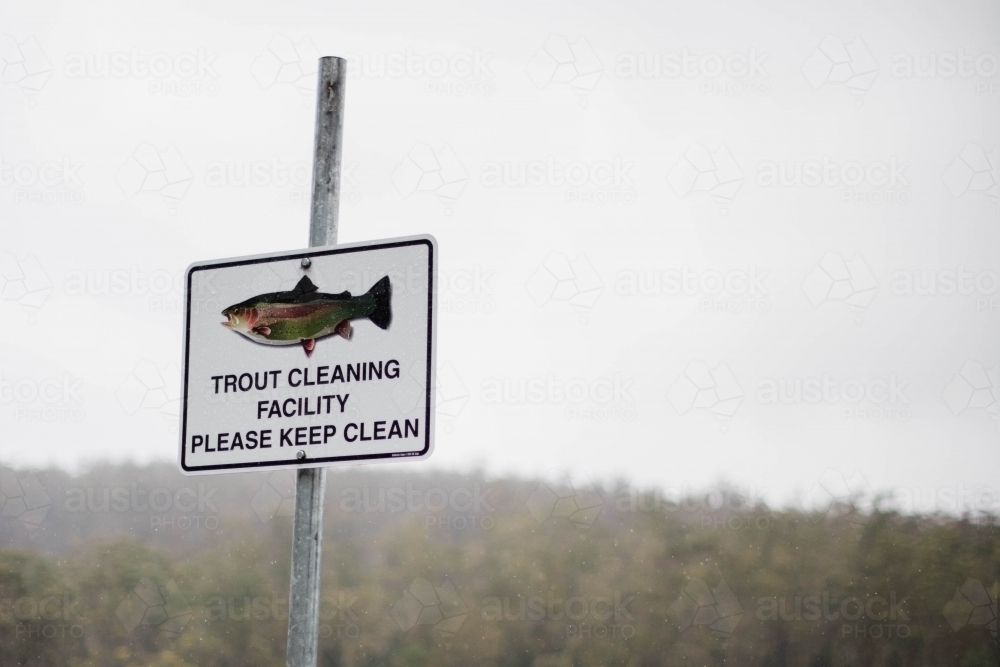 Trout cleaning facility sign with bush in background - Australian Stock Image