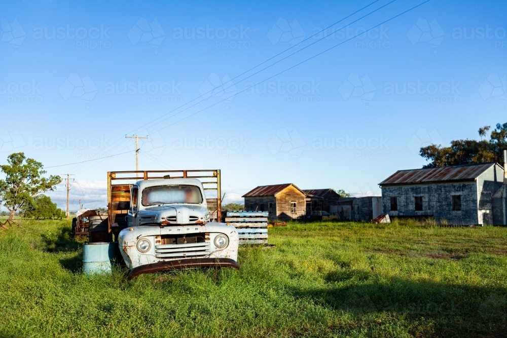 Truck and farm sheds in green paddock on farm - Australian Stock Image