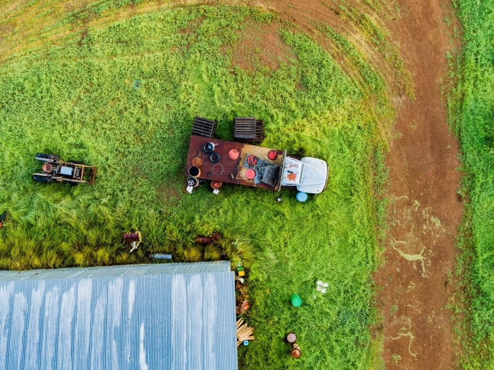 Truck and old farm junk seen from overhead on green farm - Australian Stock Image