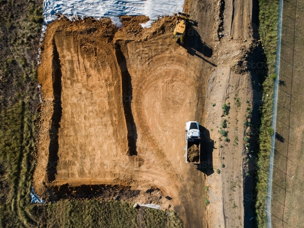 Truck transporting load of dirt around worksite - Australian Stock Image