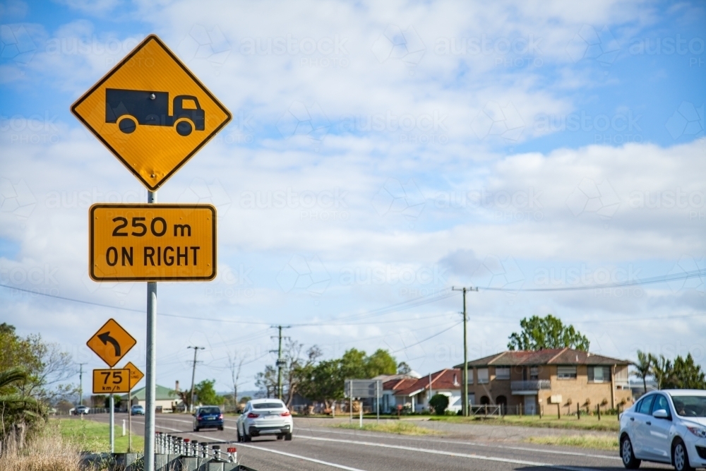 Trucks 250m on right sign beside highway - Australian Stock Image