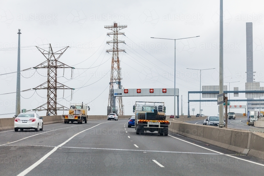 Trucks and cars on road in Docklands, Melbourne, Victoria about to cross Blote Bridge - Australian Stock Image