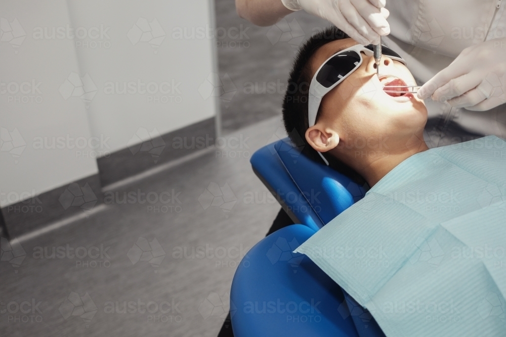 Tween boy having his teeth checked by dentist, oral health - Australian Stock Image