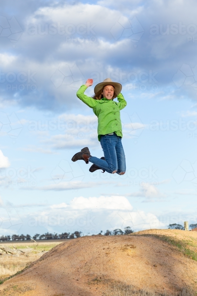 Tween country girl jumping outdoors - Australian Stock Image