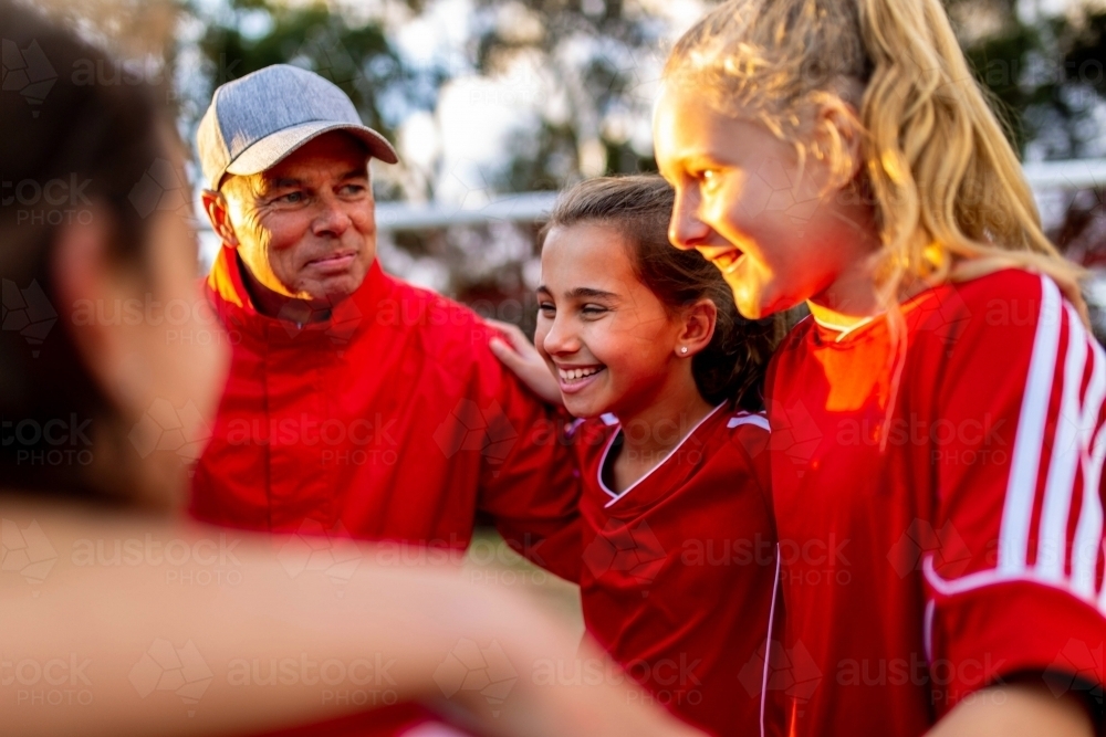 Tween girls football team members in a close pre-game huddle - Australian Stock Image