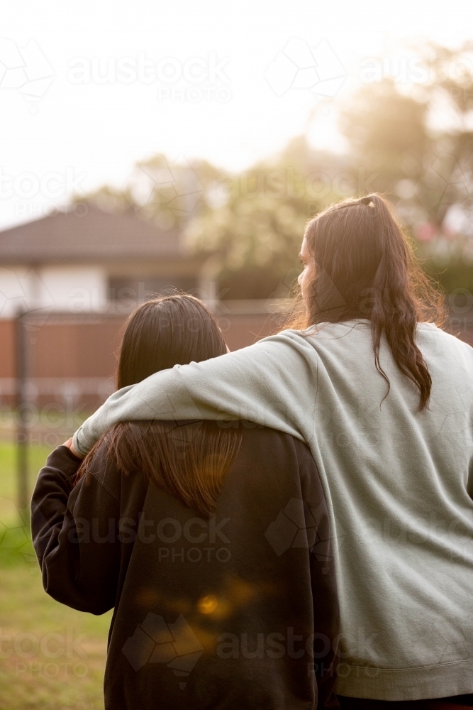 Two Aboriginal teenagers walking together in afternoon - Australian Stock Image